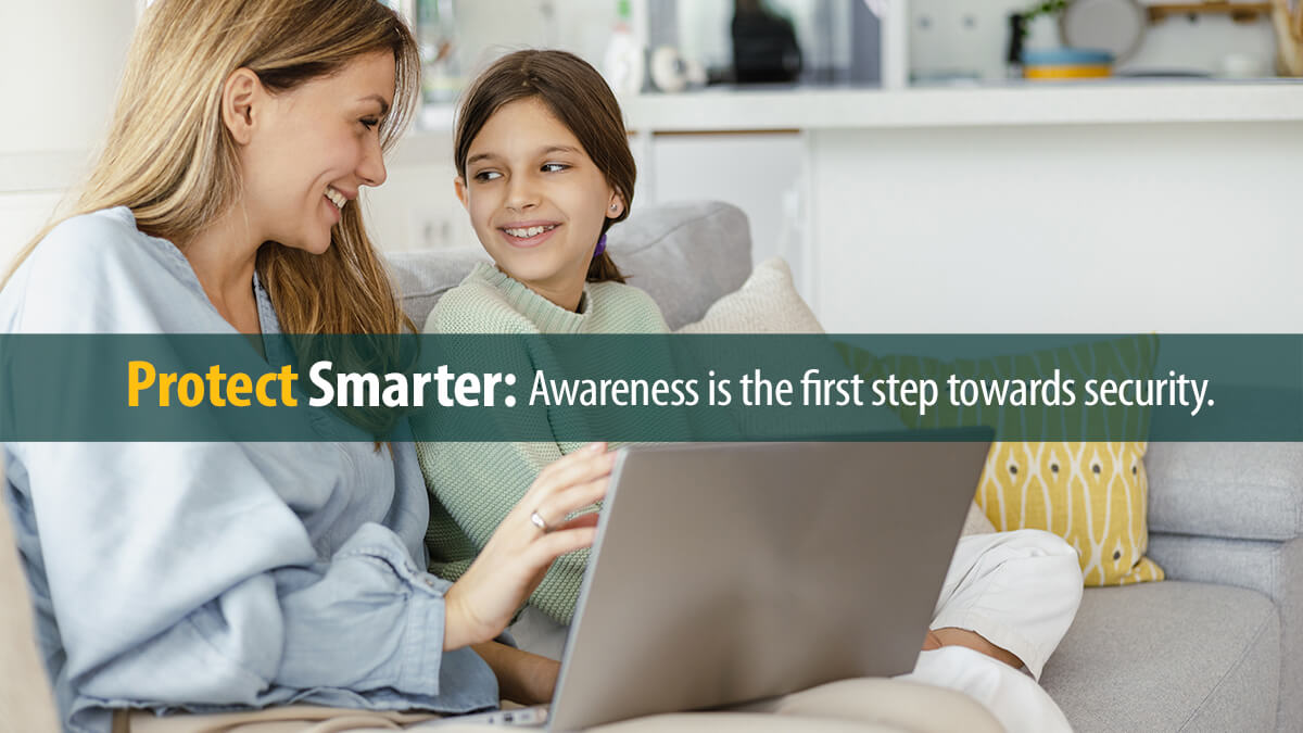 Mother and daughter sitting on the couch and using a laptop.